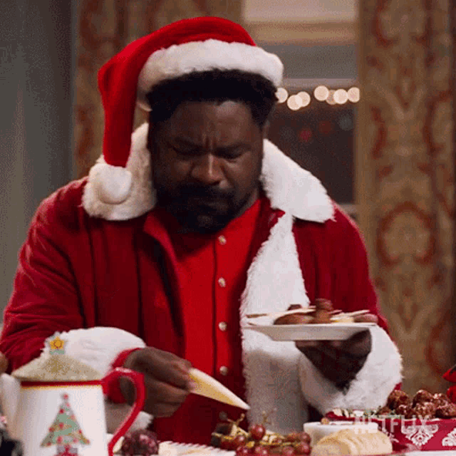a man dressed as santa claus holds a plate of food in his hand