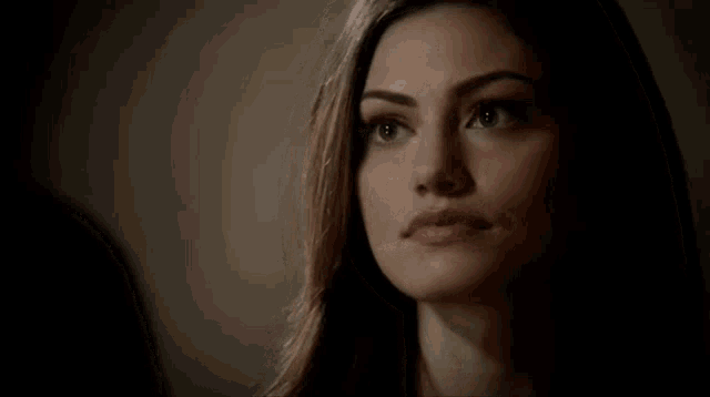 a close up of a woman 's face with a dark background .
