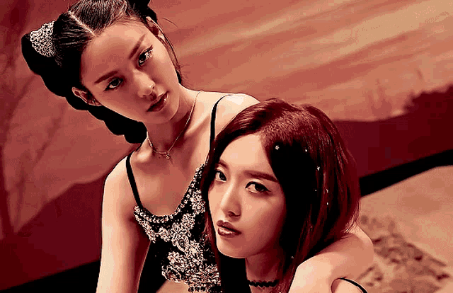 two women are posing for a picture with one wearing a necklace