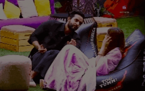 a man sits next to a woman on a bean bag chair that says too yumm