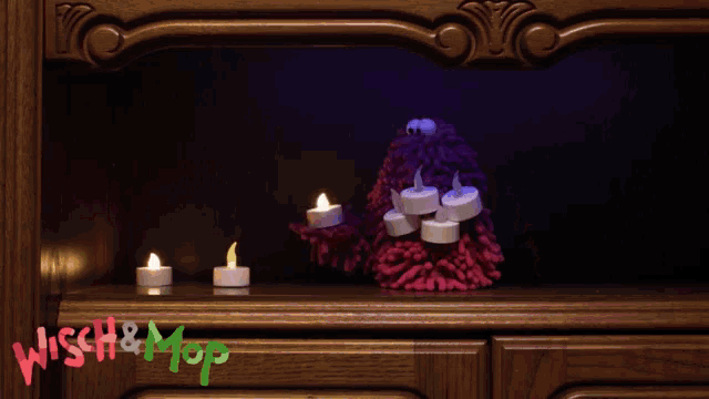 a shelf with candles and the words wish & mop on the bottom