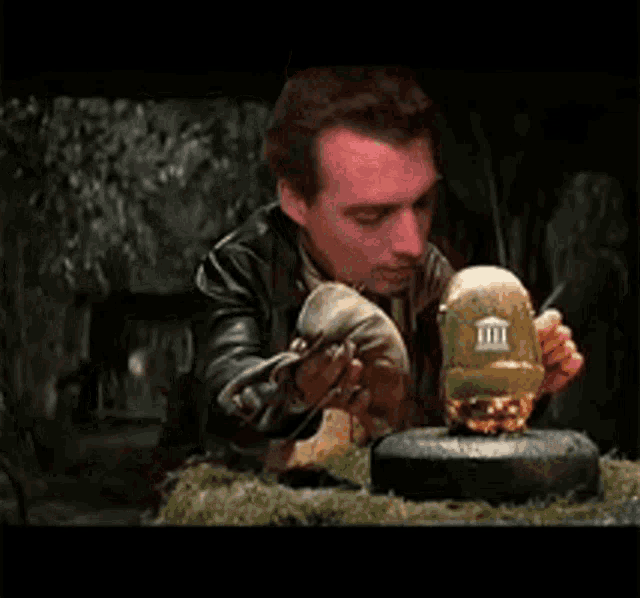 a man in a leather jacket is holding a bottle of milk in his hands