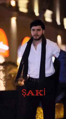 a man in a white shirt and black scarf with the word saki on the bottom
