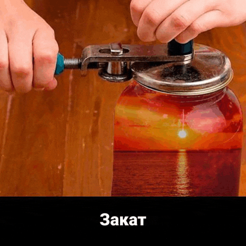a person is opening a jar with a jar opener on a table .