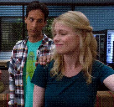 a man in a plaid shirt stands behind a woman in a blue shirt