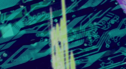 a close up of a blue and green circuit board with a yellow light coming out of it