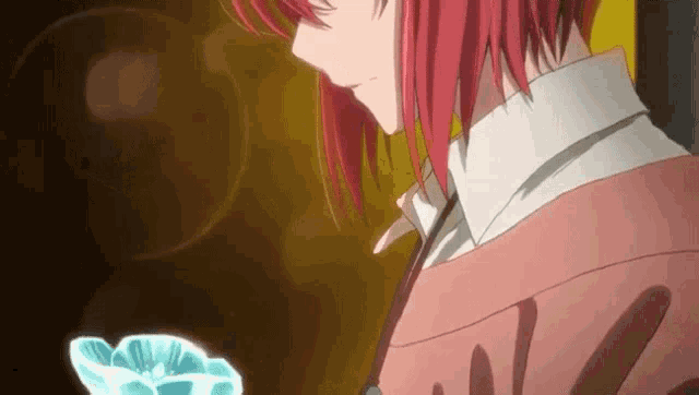 a close up of a girl with red hair holding a flower in her hand .
