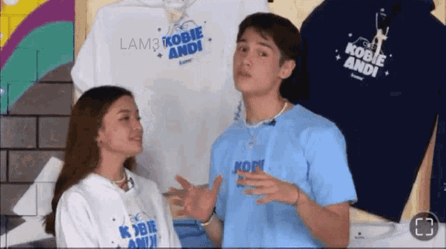 a man and a woman are standing next to each other in front of shirts that say lam3 kobie andi on them