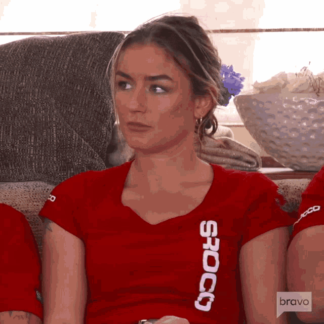 a woman wearing a red shirt that says bravo on the front