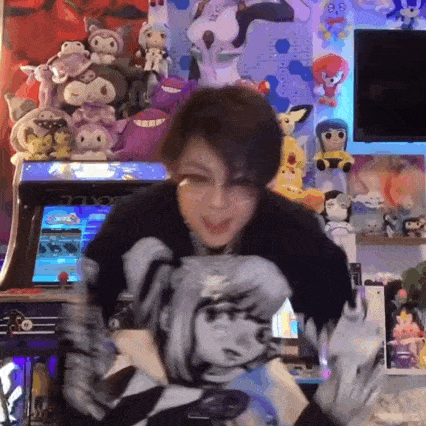 a woman is holding a pillow with a picture of a girl on it in front of a bunch of stuffed animals .