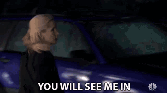 a woman standing in front of a blue car with the words you will see me in