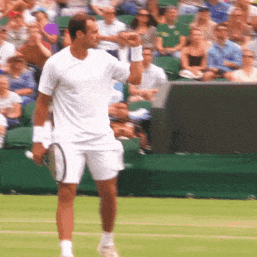 a man in a white shirt is holding a tennis racquet on a tennis court