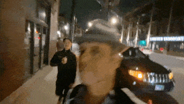 a man in a cowboy hat is walking down a street in front of a building that says lawrence endodont