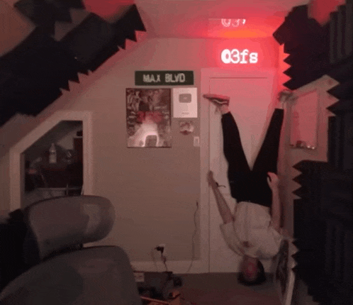 a man is doing a handstand in front of a max blvd sign