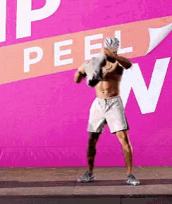 a shirtless man is standing in front of a sign that says " peel "