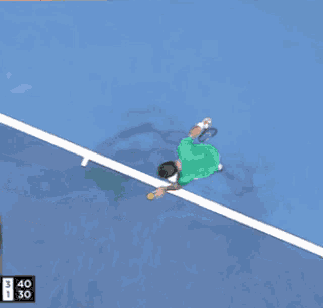 a man in a green shirt is swinging a tennis racket on a tennis court