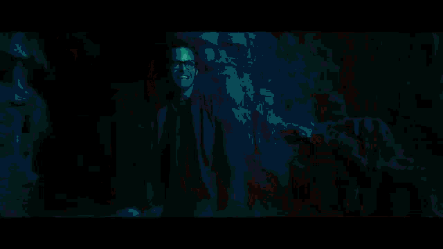 a person is swimming in a dark room with a light shining on them