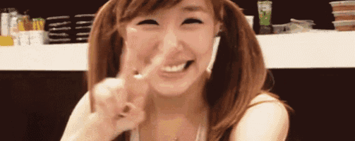 a woman with pigtails is making a peace sign with her finger