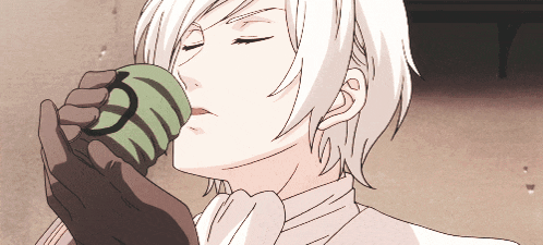 a man with white hair is drinking from a green cup with a circle on it
