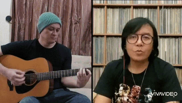 a man is playing an acoustic guitar next to another man