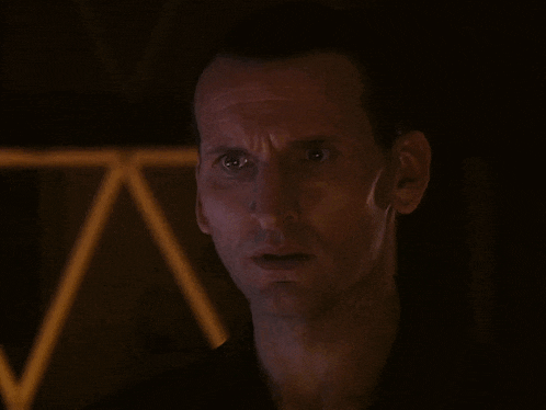 a close up of a man 's face with a triangle in the background