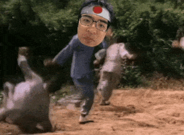 a man wearing glasses and a headband with a red circle on it is running in the dirt