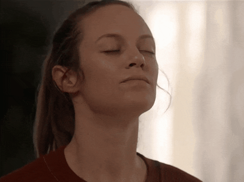 a woman with her eyes closed and her hair in a ponytail