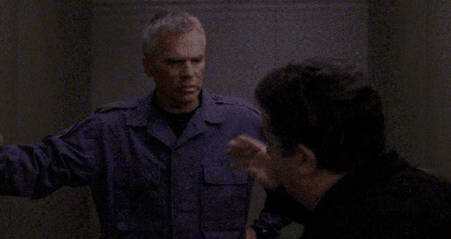 a man in a military uniform is talking to another man