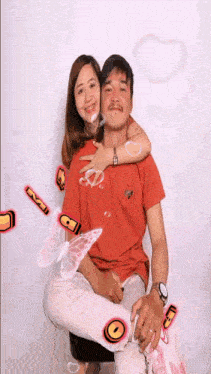 a man and a woman are posing for a picture with butterflies and hearts flying around them .