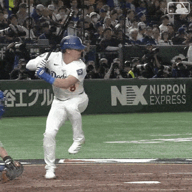 a baseball player is swinging a bat in front of an advertisement for nex express