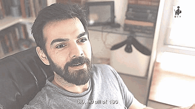 a man with a beard is sitting in a chair with the words 80 90 all of 100 written below him