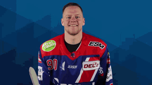a hockey player wearing a blue and red jersey with the number 90 on it