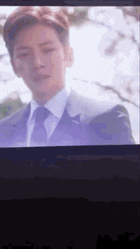 a man in a suit and tie is shown on a screen
