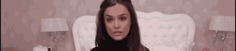 a woman in a black turtleneck is sitting in a white chair .