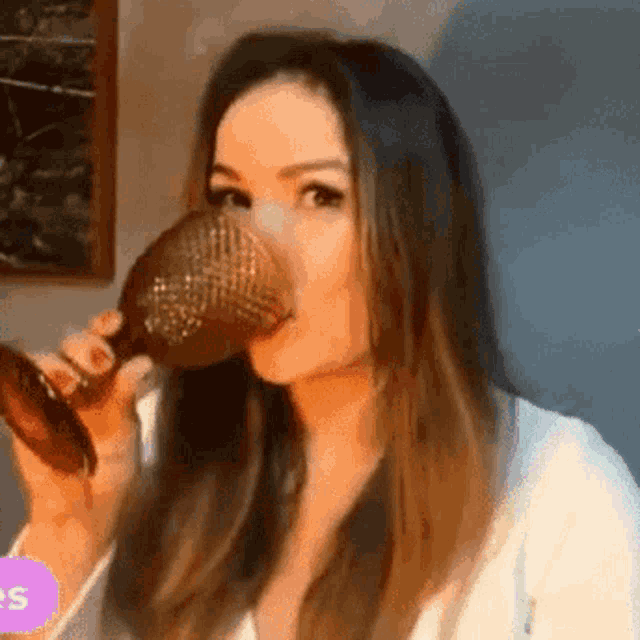 a woman is drinking a glass of wine from a glass .