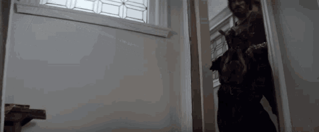 a man and a dog are standing in a doorway in a room .