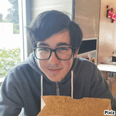 a young man wearing glasses is smiling while holding a tortilla chip in front of him