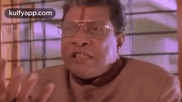 a man wearing glasses is making a funny face with his hands .