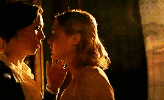 a couple of women are standing next to each other and kissing .