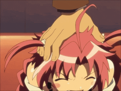 a person 's hand is on a girl 's head with red hair