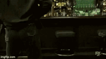 a man sitting at a bar looking at a sign that says minors