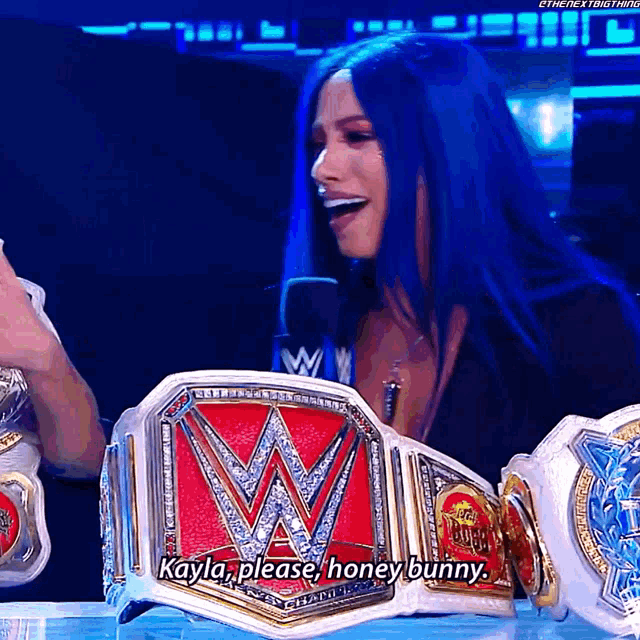 a woman with blue hair is wearing a wrestling championship belt and says kayla please honey bunny