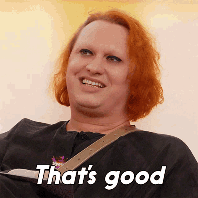 a woman with red hair is smiling with the words that 's good above her