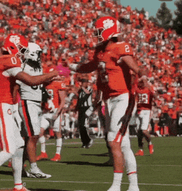 a football player with the number 2 on his jersey is being hugged by another player