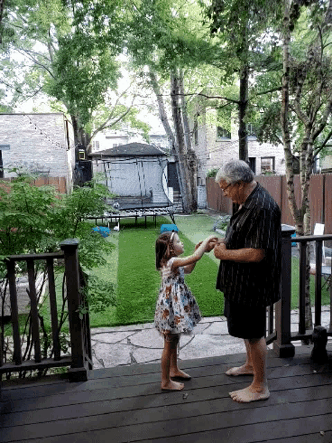 a man and a little girl holding hands on a deck