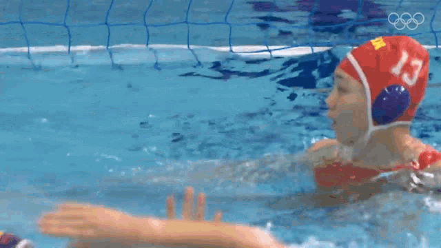 two female water polo players are playing a game in a pool