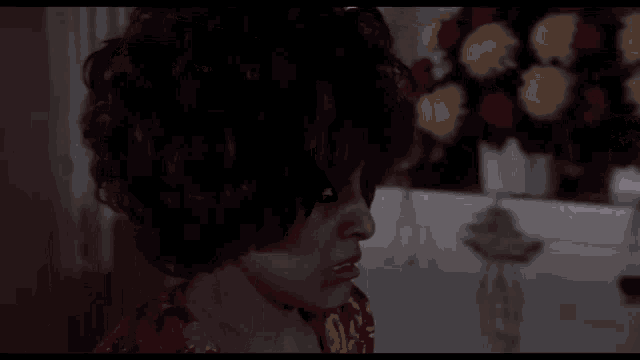 a woman in a red dress is standing next to another woman in a dark room .