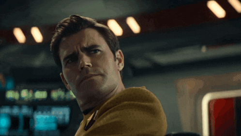 a man in a yellow uniform looks at the camera with a serious expression on his face