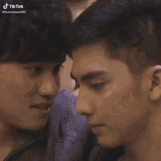 two young men are kissing each other on the cheeks .