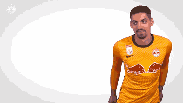 a man wearing an orange jersey with the word red bull on it